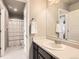 Clean bathroom featuring a vanity, a large mirror and an adjacent shower and toilet room at 8768 Foxfire St, Firestone, CO 80504