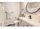 Bright bathroom with patterned tile floor, white vanity, round mirror, and shower/tub combination at 8768 Foxfire St, Firestone, CO 80504
