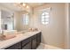 Well-lit bathroom with a large mirror, vanity, and a unique window for natural light at 8768 Foxfire St, Firestone, CO 80504
