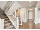 Bright foyer with hardwood floors, staircase, and a view of the front door with glass detailing at 8768 Foxfire St, Firestone, CO 80504