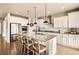 Modern kitchen featuring a large island with seating, stainless steel appliances, and white cabinetry at 8768 Foxfire St, Firestone, CO 80504