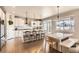 Eat-in kitchen with granite countertops, white cabinets, stainless steel appliances, and hardwood floors at 8768 Foxfire St, Firestone, CO 80504