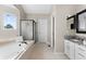 Bright bathroom featuring a soaking tub with tile surround, glass shower, and vanity with granite countertops at 20650 Parker Vista Cir, Parker, CO 80138