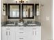 Bathroom vanity area featuring dual sinks, granite countertop, white cabinets, and framed mirrors at 20650 Parker Vista Cir, Parker, CO 80138