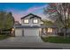 Charming two-story home with a three-car garage and a well-manicured lawn under a colorful sunset at 20650 Parker Vista Cir, Parker, CO 80138