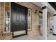 Close-up of the front door showcasing the brick facade and covered porch with seating at 20650 Parker Vista Cir, Parker, CO 80138