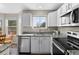 Well-lit kitchen featuring white cabinets, granite countertops, and stainless steel appliances at 20650 Parker Vista Cir, Parker, CO 80138