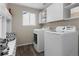 Convenient laundry room with modern washer and dryer, built-in storage, and ample counter space at 20650 Parker Vista Cir, Parker, CO 80138