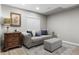 Living area featuring a comfortable sofa, ottoman, side table, and a window with blinds at 20650 Parker Vista Cir, Parker, CO 80138