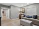Living area featuring a comfortable sofa, ottoman, side table, and a window with blinds at 20650 Parker Vista Cir, Parker, CO 80138
