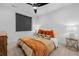 Cozy bedroom featuring a queen-size bed with orange accents, window, and bedside tables with lamps at 9741 Taylor River Cir, Littleton, CO 80125