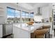 Bright kitchen with large windows, stainless steel appliances and island with seating at 9741 Taylor River Cir, Littleton, CO 80125