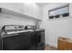 Clean, organized laundry room featuring front-load washer/dryer, white cabinetry and a small window at 9741 Taylor River Cir, Littleton, CO 80125