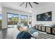Stylish living room features a curved sofa, large windows, and access to a patio area at 9741 Taylor River Cir, Littleton, CO 80125