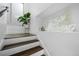 Stylish staircase with wood steps, white risers, and modern decor at 9741 Taylor River Cir, Littleton, CO 80125