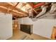 Unfinished basement featuring painted brick walls, exposed ductwork, and a vintage dresser for storage at 444 S Pearl St, Denver, CO 80209