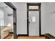 Hallway leading to a living room featuring a white door with black trim and hardwood floors at 444 S Pearl St, Denver, CO 80209