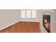 Living room featuring hardwood floors, a cozy fireplace, and large windows at 9965 E 143Rd Way, Brighton, CO 80602