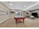 Finished basement game room with pool table, TV, and neutral colored carpet at 12732 Fisher Dr, Englewood, CO 80112