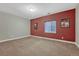 Cozy bedroom with red accent wall, neutral carpeting, and natural light, providing a comfortable and inviting space at 12732 Fisher Dr, Englewood, CO 80112