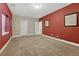 Bedroom featuring red accent wall, neutral carpeting, and two doors offering an inviting and comfortable atmosphere at 12732 Fisher Dr, Englewood, CO 80112