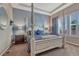 Luxurious bedroom with tray ceiling, four-poster bed, and shuttered windows at 12732 Fisher Dr, Englewood, CO 80112
