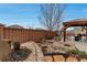 Landscaped backyard with rock accents, stone pavers, and an outdoor kitchen featuring a grill at 5519 Genoa St, Denver, CO 80249