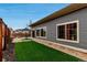 Backyard showcasing a manicured yard with artificial turf, stone pavers, and a sliding glass door to the house at 5519 Genoa St, Denver, CO 80249