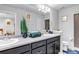 Bathroom featuring double sinks with a shared mirror, dark cabinets and decor at 5519 Genoa St, Denver, CO 80249