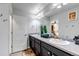 Bathroom featuring double sinks with a shared mirror, dark cabinets and decor at 5519 Genoa St, Denver, CO 80249