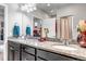 Bathroom featuring double sinks with granite countertops and dark cabinets, and a large mirror at 5519 Genoa St, Denver, CO 80249