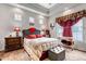 Comfortable primary bedroom with a cozy chair, bedside tables, and a window at 5519 Genoa St, Denver, CO 80249