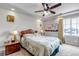 A carpeted bedroom with a fan, side tables, and a large window for natural light at 5519 Genoa St, Denver, CO 80249