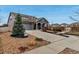 Inviting home featuring a well-manicured lawn, concrete driveway, mature tree, and covered front porch at 5519 Genoa St, Denver, CO 80249
