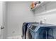 Laundry room featuring front-load washer and dryer set, with overhead storage shelf at 5519 Genoa St, Denver, CO 80249