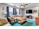 Carpeted living room boasts natural light, a ceiling fan, a flat screen tv and comfortable furniture at 5519 Genoa St, Denver, CO 80249
