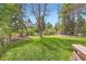 Expansive backyard featuring a lush lawn, mature trees, wooden fence, and a peaceful setting at 6432 E Jamison Cir, Centennial, CO 80112