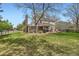 Spacious backyard with lush green grass, mature trees, and a large deck for outdoor dining at 6432 E Jamison Cir, Centennial, CO 80112