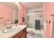 Pink bathroom featuring a sliding glass door shower, vanity with sink, and neutral tile at 6432 E Jamison Cir, Centennial, CO 80112
