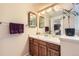 Bathroom with wood cabinets, double framed mirrors, and plant on the counter at 6432 E Jamison Cir, Centennial, CO 80112