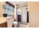 Bright bathroom features glass shower door, window for natural light, and classic fixtures at 6432 E Jamison Cir, Centennial, CO 80112