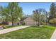 Charming two-story home featuring a well-maintained lawn, mature trees, and a two-car garage at 6432 E Jamison Cir, Centennial, CO 80112