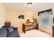 Bright home office boasts large desk, comfortable seating, and natural light from the window at 6432 E Jamison Cir, Centennial, CO 80112