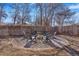 Backyard with a gravel fire pit area circled by Adirondack chairs surrounded by a wooden fence at 821 Collyer St, Longmont, CO 80501