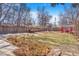 Large grassy backyard with a red shed, a patio set, and graveled fire pit area at 821 Collyer St, Longmont, CO 80501