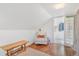 Bright bedroom featuring sloped ceilings, hardwood floors, a sitting chair, and an ensuite bathroom at 821 Collyer St, Longmont, CO 80501