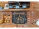 Close-up of the brick fireplace with wooden mantel at 821 Collyer St, Longmont, CO 80501