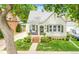 Charming bungalow featuring a well-manicured front yard with landscaped flower beds, a brick entryway, and a cozy front porch at 821 Collyer St, Longmont, CO 80501