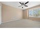 Neutral bedroom with ceiling fan, large window, and carpet at 8985 Edgewood Ln, Highlands Ranch, CO 80130