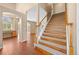 Bright foyer with wood floors, staircase, and arched doorway leading to office with built in desk at 8985 Edgewood Ln, Highlands Ranch, CO 80130